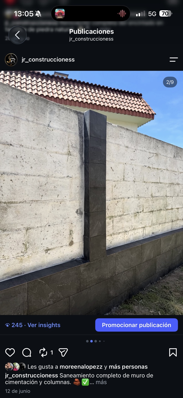 Muro exterior con revestimiento oscuro en el zócalo y los pilares